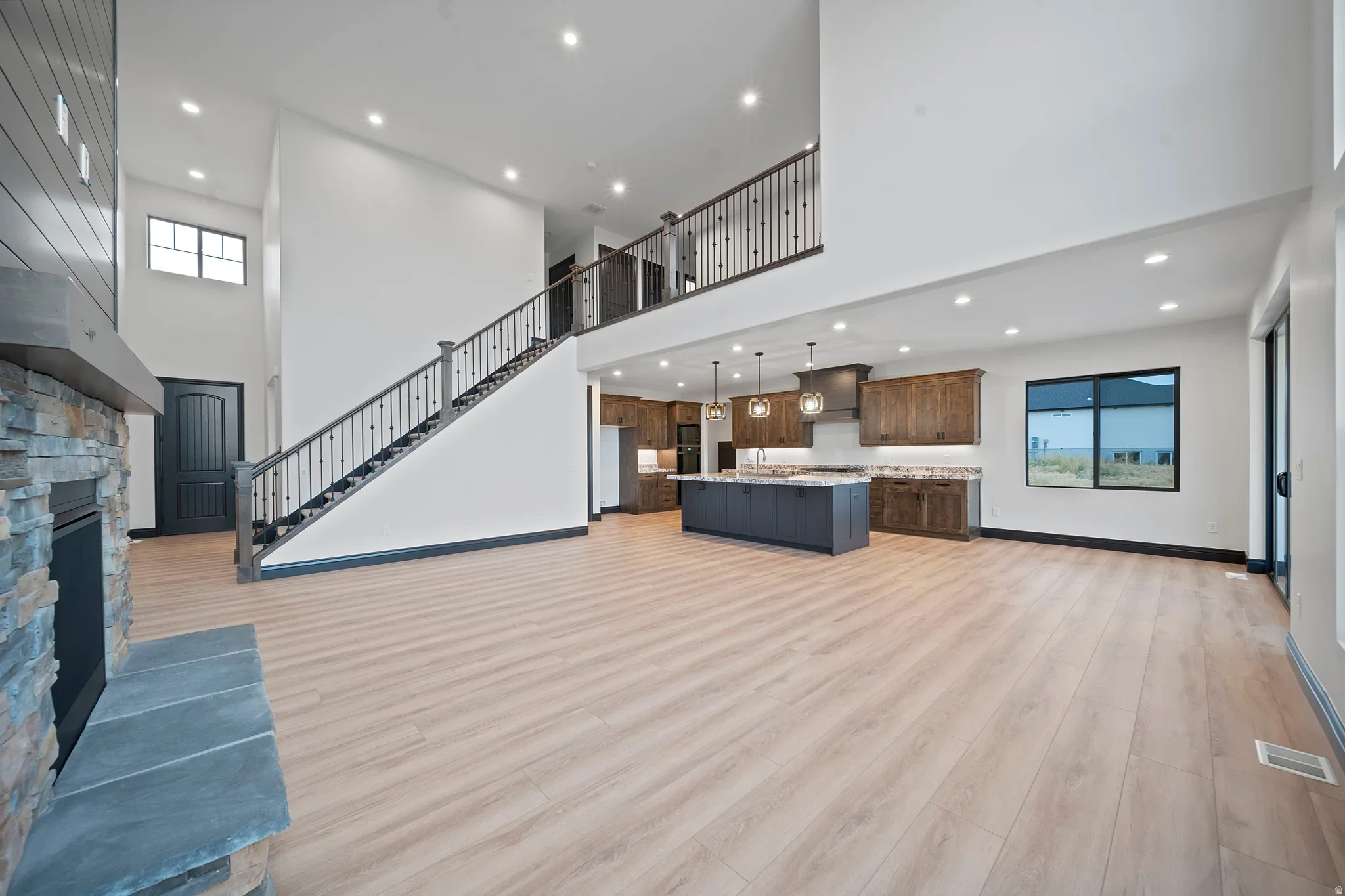 An Eagle Point Homes open interior with tall ceilings, a stairway, and wood-look flooring